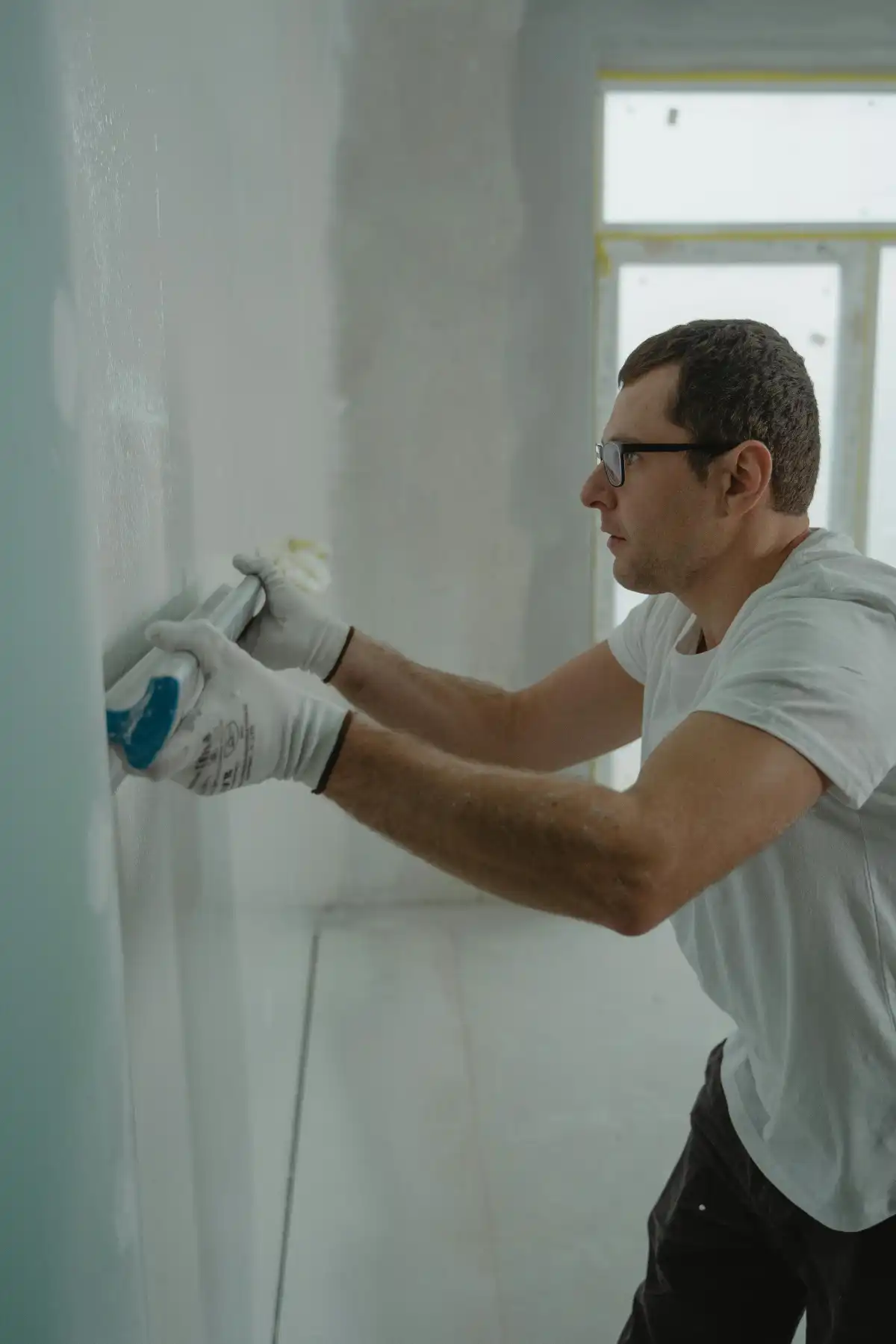 Professional drywall technician repairing a wall